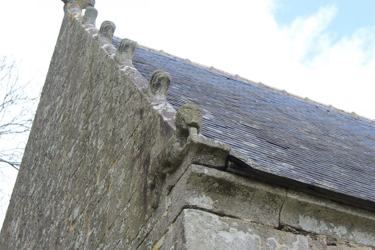 Rangée de gargouilles en pierre sur la toiture de la chapelle Saint-Nicodème à Ploéven