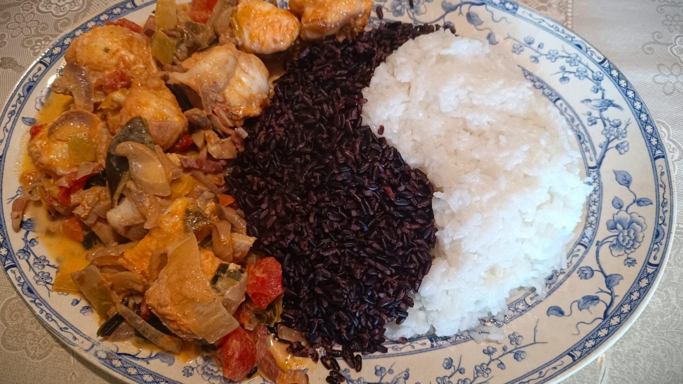 Assiette de lotte nappée façon armoricaine “forestière”, sauce onctueuse tomate-Armagnac crémée, servie avec duo de riz noir et riz parfumé.